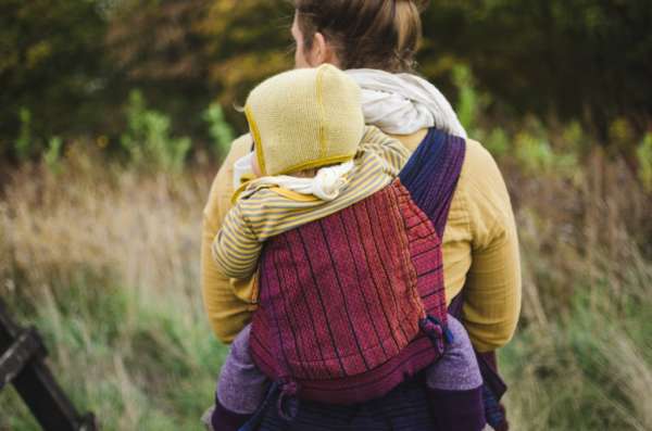 Porte bébé hybride, ceinture à clips et bretelles à nouer. Pour porter dès la naissance de façon physiologique. Avec le wrapmysol de Girasol. De 0 à 3 ans. Achat en Suisse chez jeteporte à Romont, fribourg